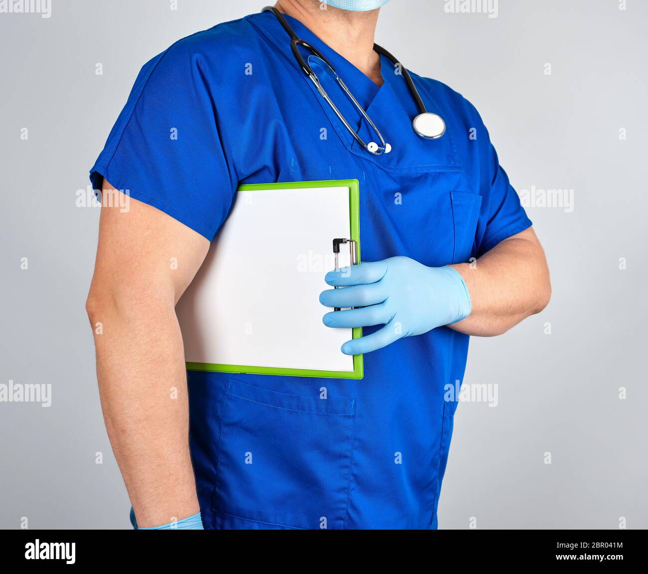 doctor in blue uniform and sterile latex gloves holds clipboard with a ...