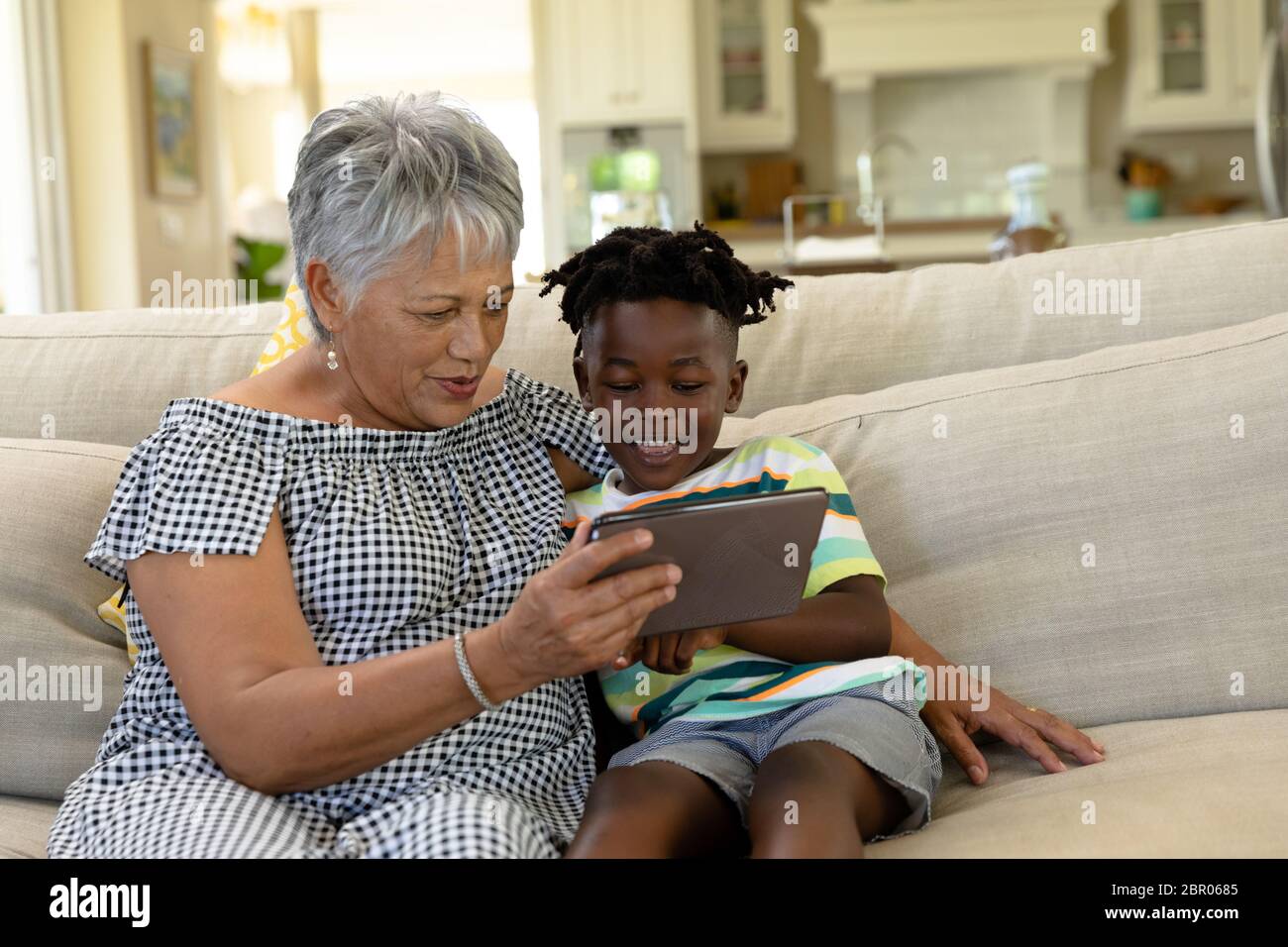 Senior mixed race woman with her grandson at home Stock Photo