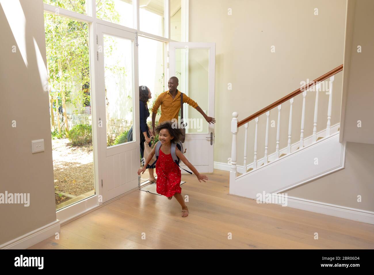 Mixed race couple and their young son and daughter arriving at home Stock Photo