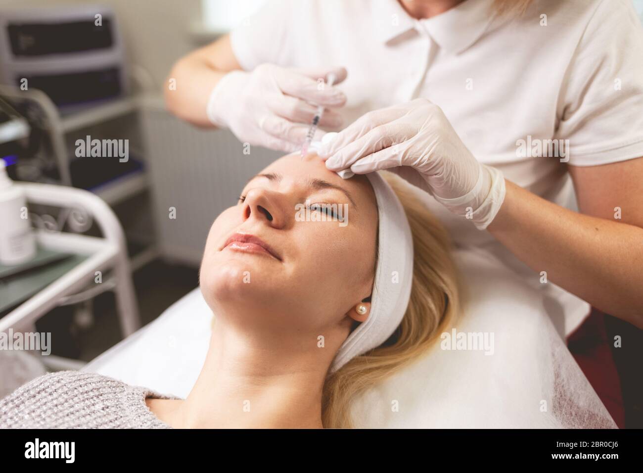 Сosmetologist doctor injects botox into the patient's forehead Stock ...