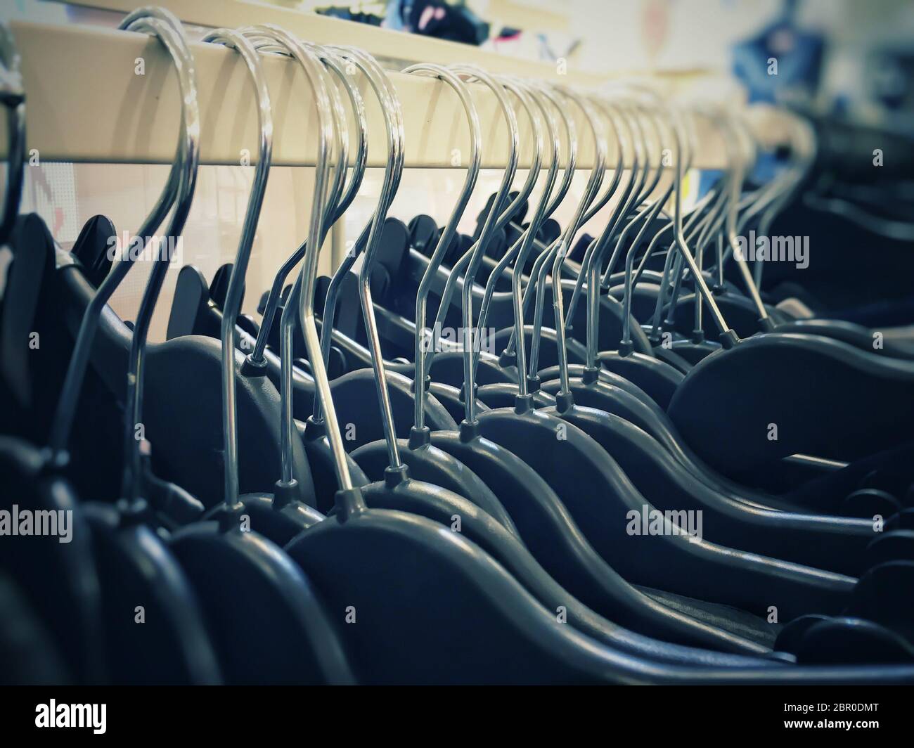 close-up view of a group of clothes hangers hanging in a row inside a shop Stock Photo