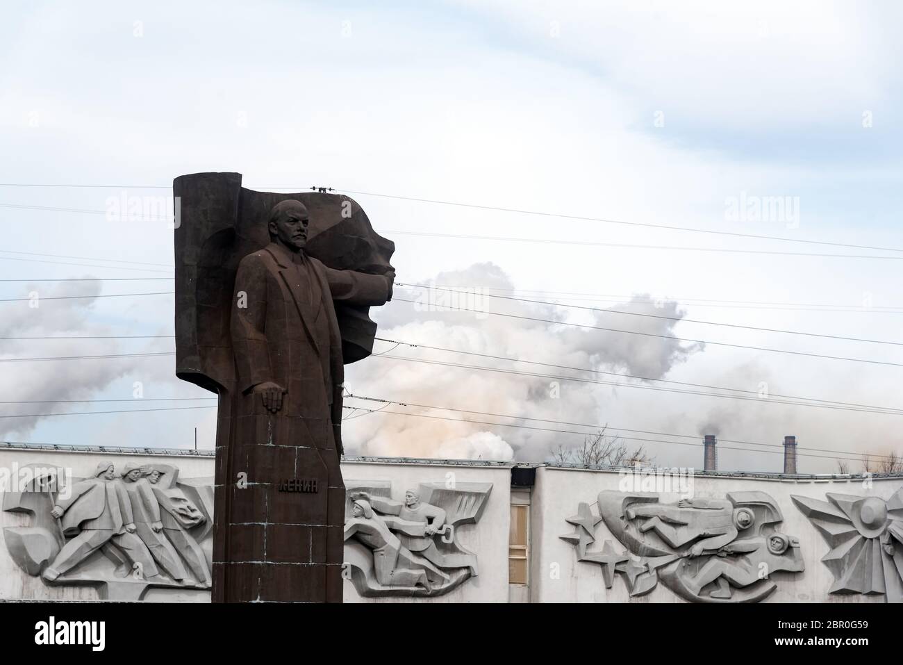 Magnitogorsk, Chelyabinsk Oblast: Monument to Vladimir Lenin in Magnitogorsk. Magnitogorsk Metallurgical Plant (MMK) building Stock Photo