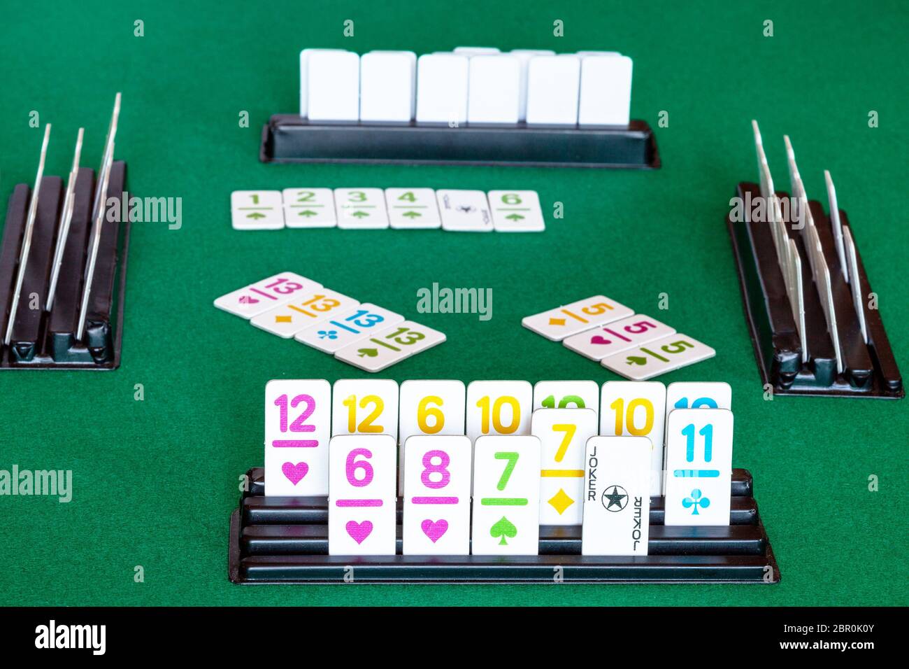 tiles in rack and gameplay in Rummy tilebased card game on green baize
