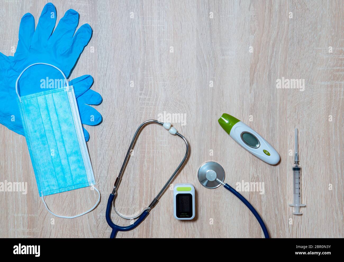 Doctor's equipment for taking tests for infection with the virus Covid-19-stethoscope, thermometer, oximeter, syringe, medical mask and disposable glo Stock Photo