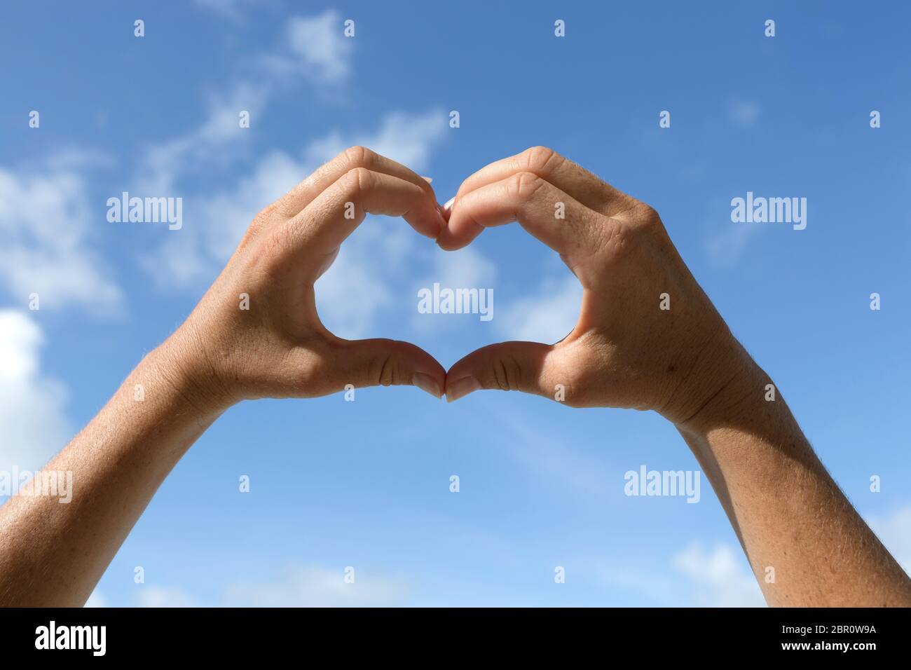 Female hands in front of blue sunny sky, vacation background Stock ...