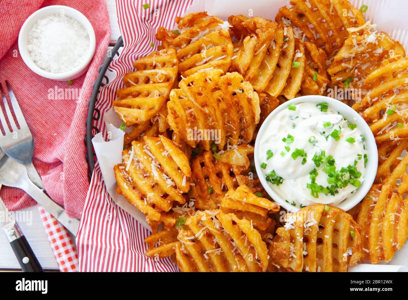 Crunchy waffle fries with sour cream dip served in a basket Stock Photo Alamy