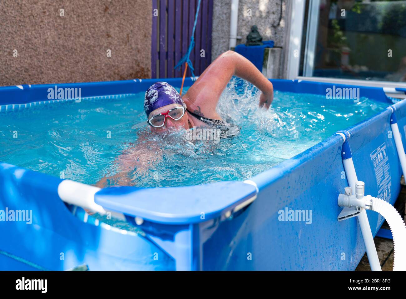 Rosyth, Scotland, UK. 20 May 2020. Jenny Waring (41) from Rosyth, Fife, a wild open water swimmer with the Fife Wild Swimmers group, during a daily dip in her garden pool. Many wild swimmers have been denied the opportunity to pursue their sport during Covid-19 lockdown and have purchased pools for their gardens to maintain their wellbeing. Iain Masterton/Alamy Live News Stock Photo