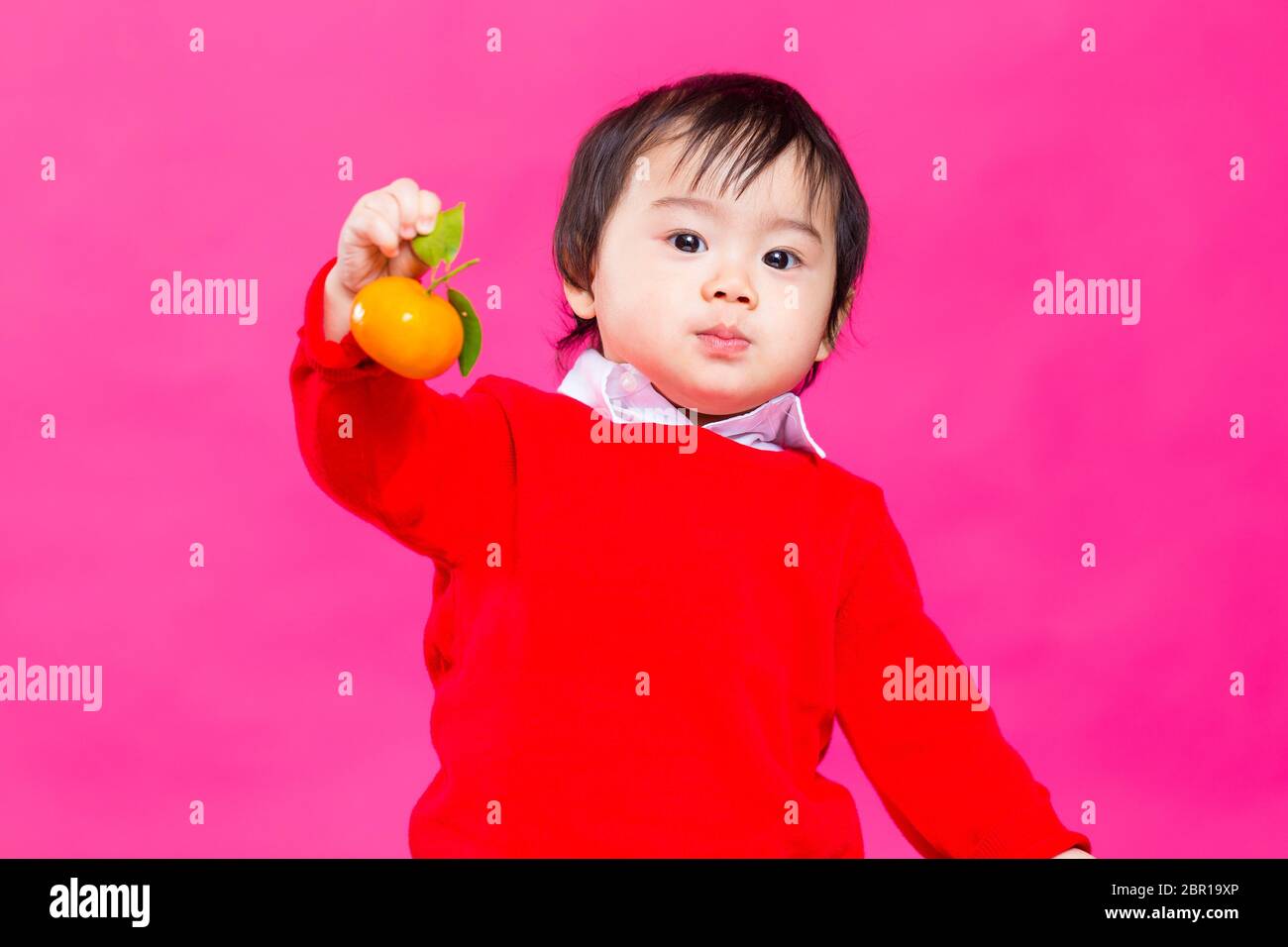Cute little baby holding citrus Stock Photo Alamy