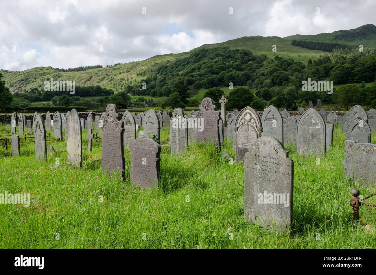 Beddgelert, North Wales, UK: Jun 3, 2017: A scenic view of the graveyard at the Church of St. Mary. The headstones are created of slate which is a com Stock Photo