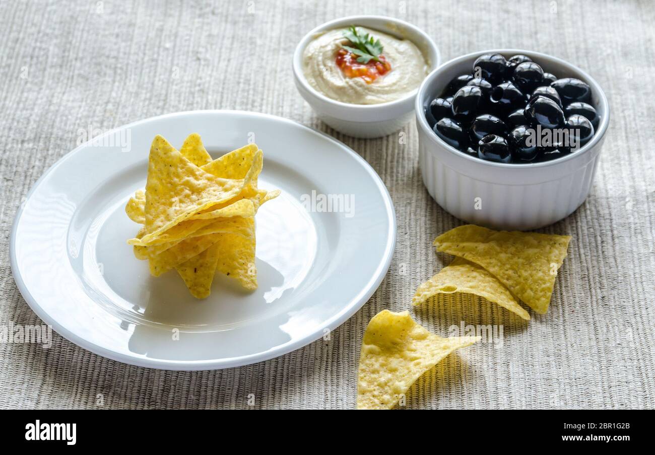 Corn chips with hummus and olives Stock Photo Alamy