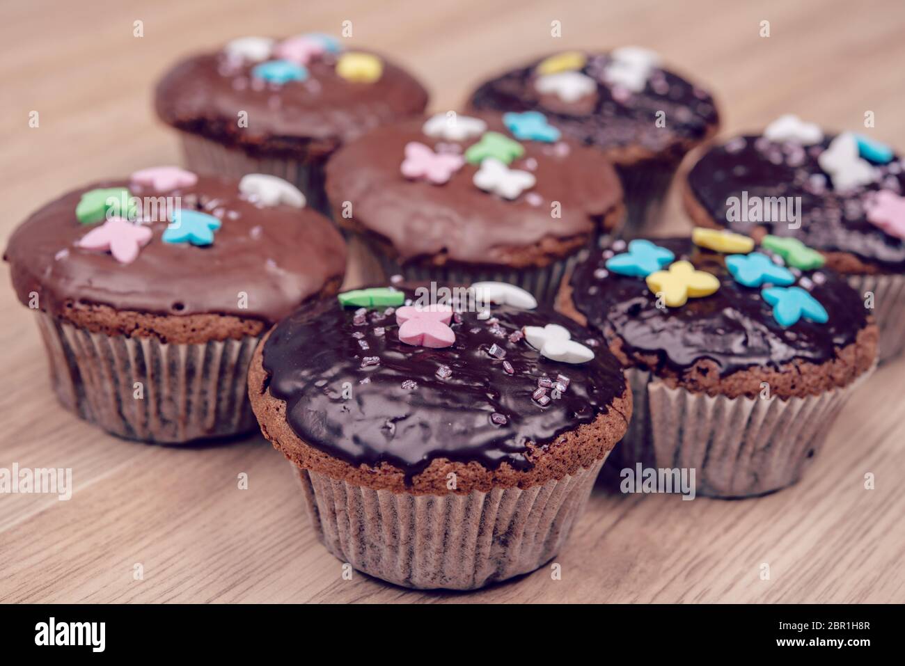 chocolate muffins with colorful decoration on wooden ground Stock Photo ...