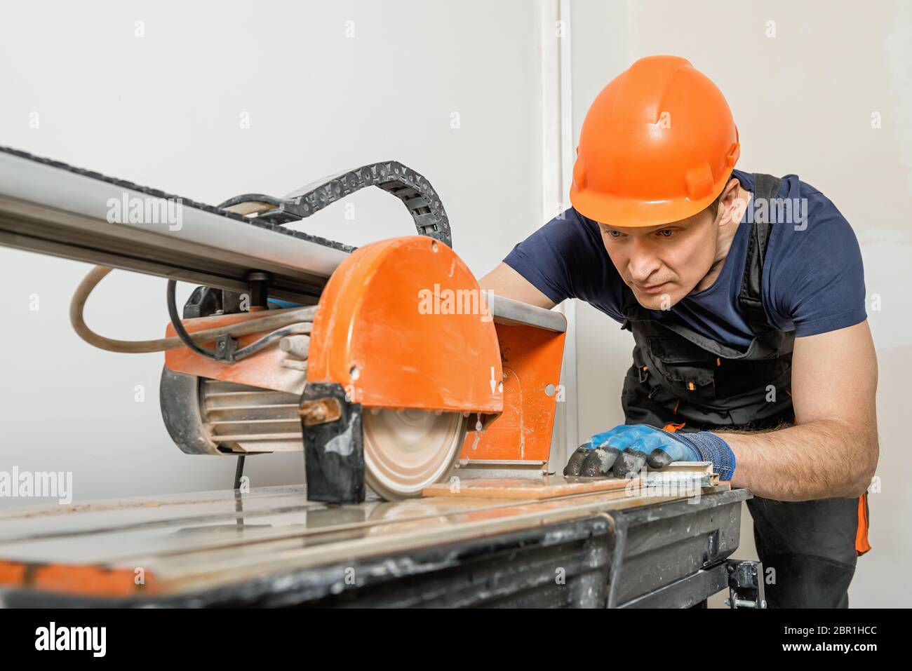 The worker is cutting a ceramic tile on a wet cutter saw machine Stock Photo Alamy