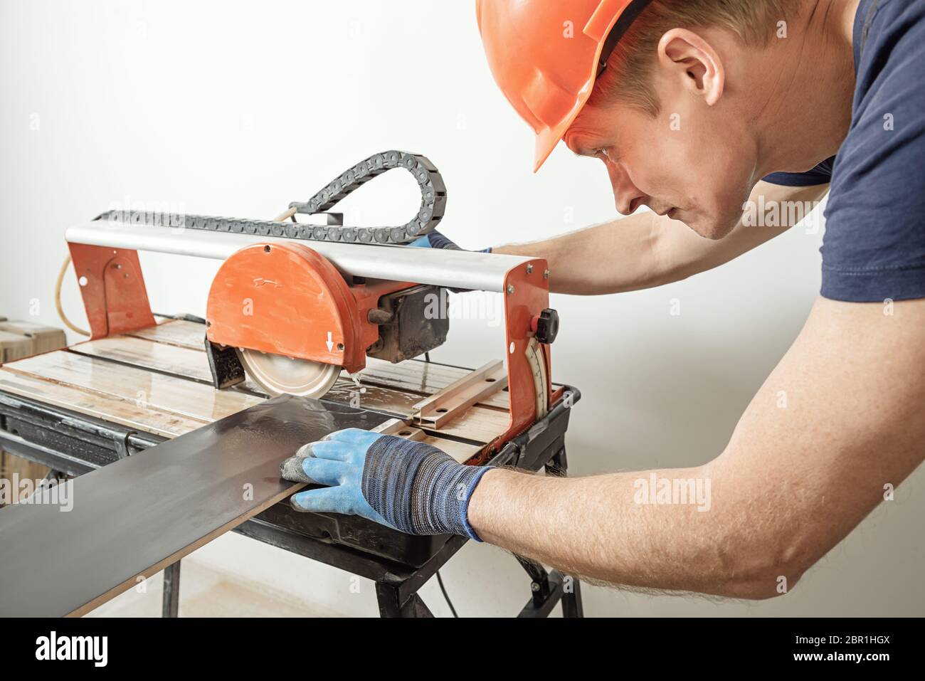 The worker is cutting a ceramic tile on a wet cutter saw machine Stock  Photo - Alamy