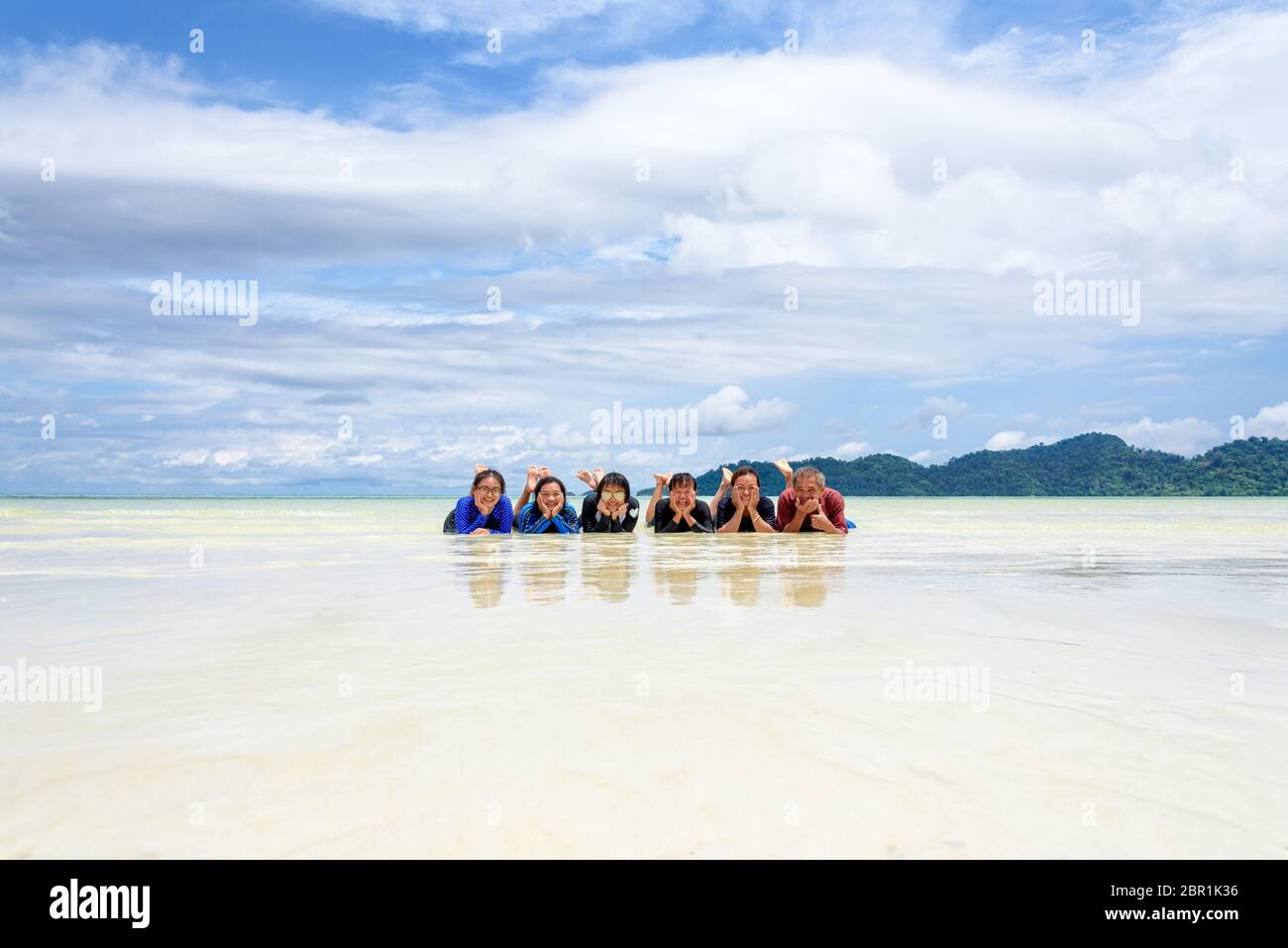 Asian people group adult and teens are family, Happy life enjoy by lying together on the beach of Ra Wi island during the sea travel vacation in summe Stock Photo