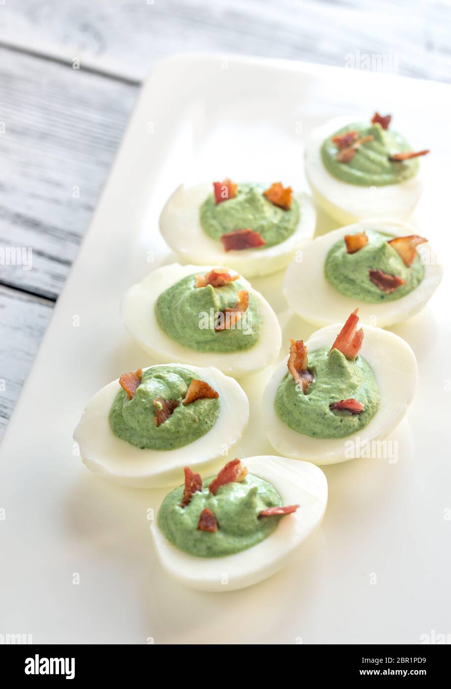 Spinach and bacon deviled eggs Stock Photo