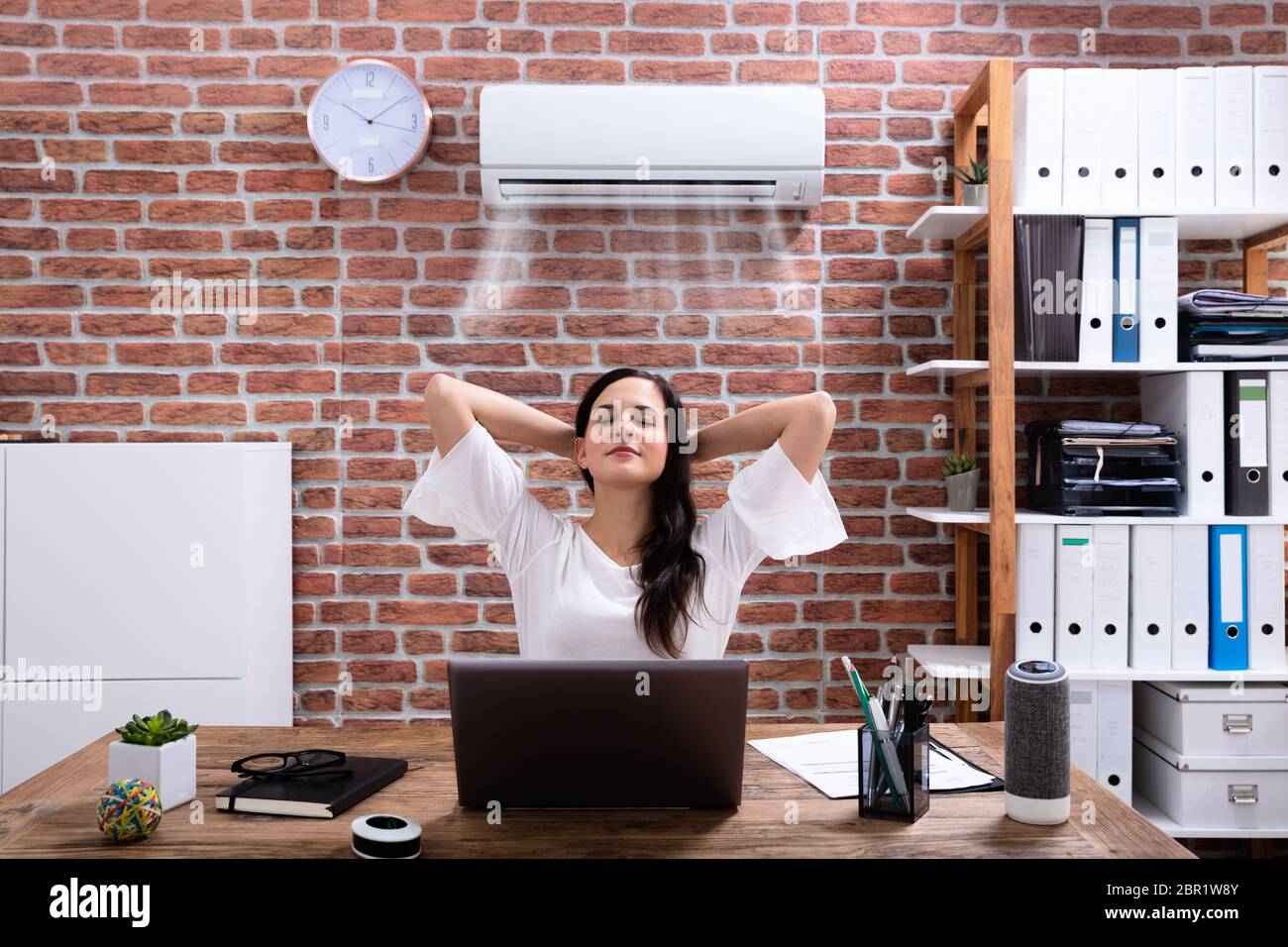 Relaxed Businesswoman Enjoying The Cooling Of Air Conditioner In The Office Stock Photo