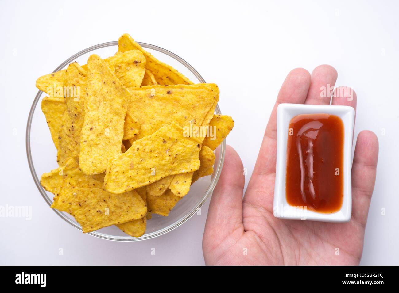 Triangular corn chips, mexican nachos with sauces tomato ketchup, close-up. Stock Photo