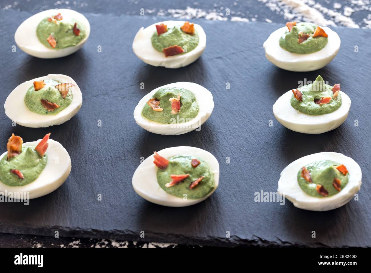 Spinach and bacon deviled eggs Stock Photo