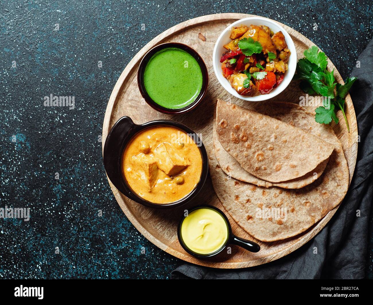 Indian cuisine dishes vegetable curry, shahi paneer, chapati, chutney. Indian food on wooden