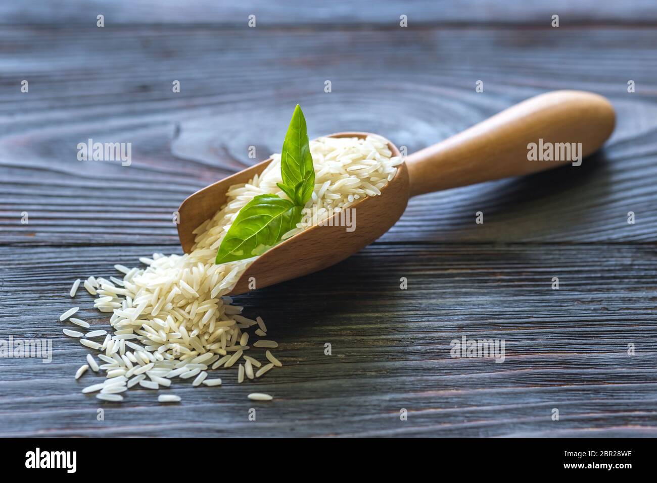 Scoop of uncooked basmati rice Stock Photo Alamy