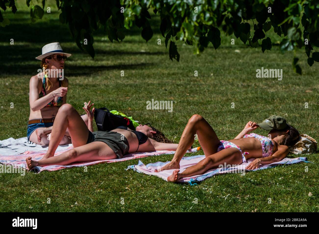 London, UK. 20th May, 2020. Sunbathing, some bring their own loungers, some just lie on towels - Enjoying the sun in St James Park as the sun comes out again. The 'lockdown' continues for the Coronavirus (Covid 19) outbreak in London. Credit: Guy Bell/Alamy Live News Stock Photo