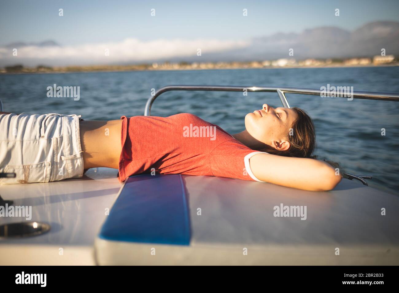 A teenage Caucasian girl enjoying her time on a boat Stock Photo