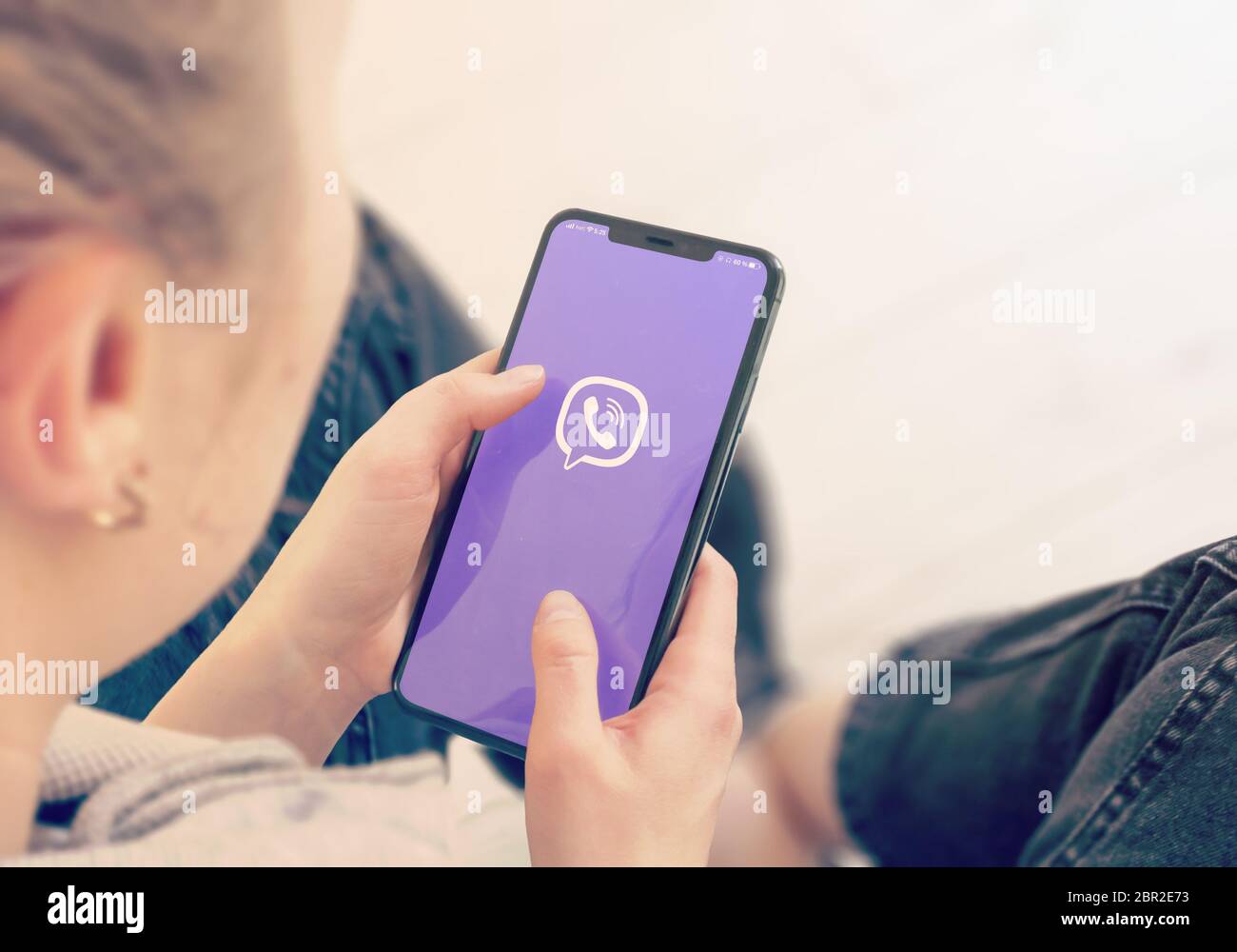 KYIV, UKRAINE-JANUARY, 2020: Viber on Smart Phone Screen. Young Girl Pointing or Texting Viber on Smart Phone During a Pandemic Self-Isolation and Coronavirus Prevention. Stock Photo
