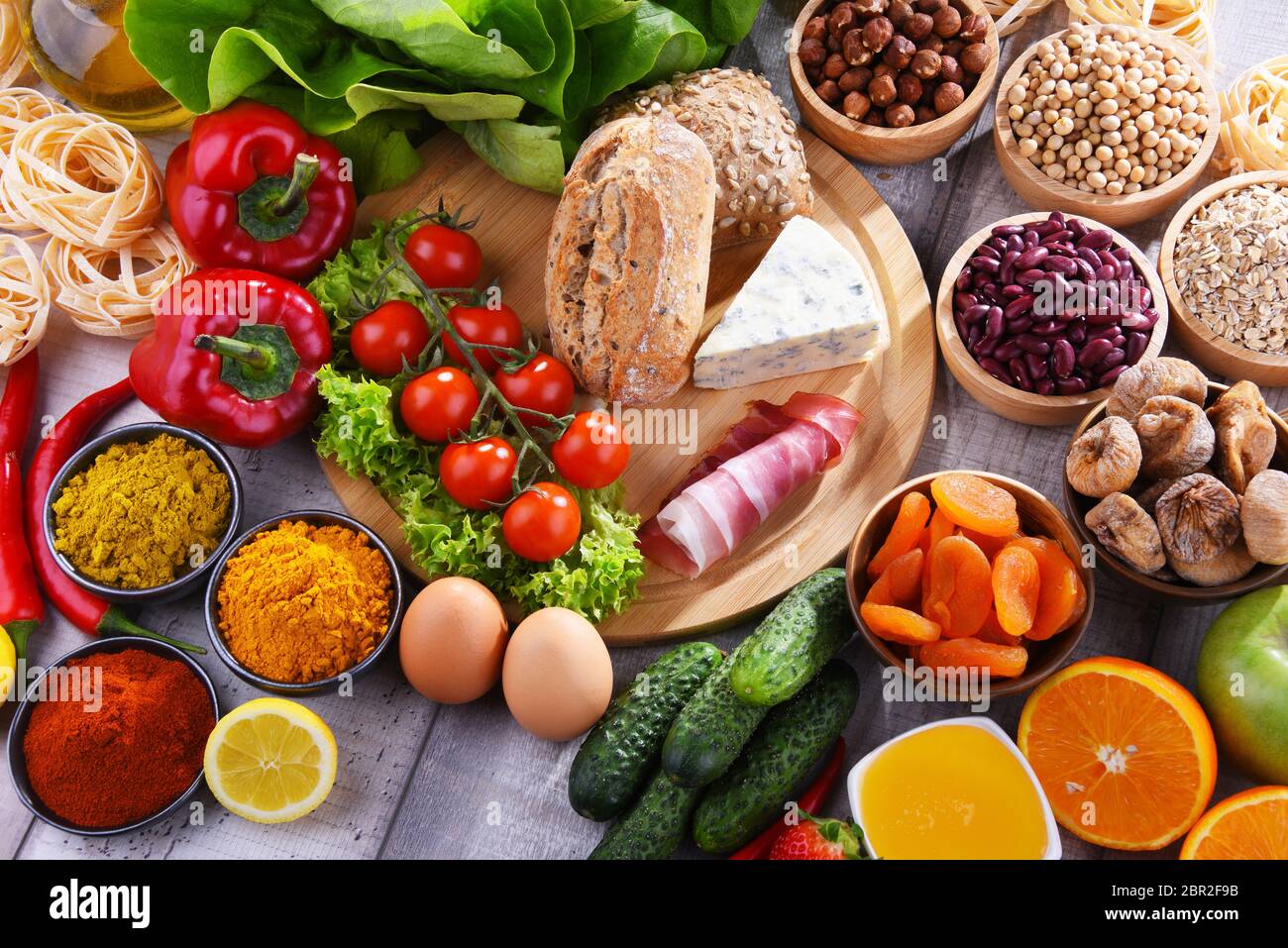 Composition with assorted organic food products on wooden kitchen table ...