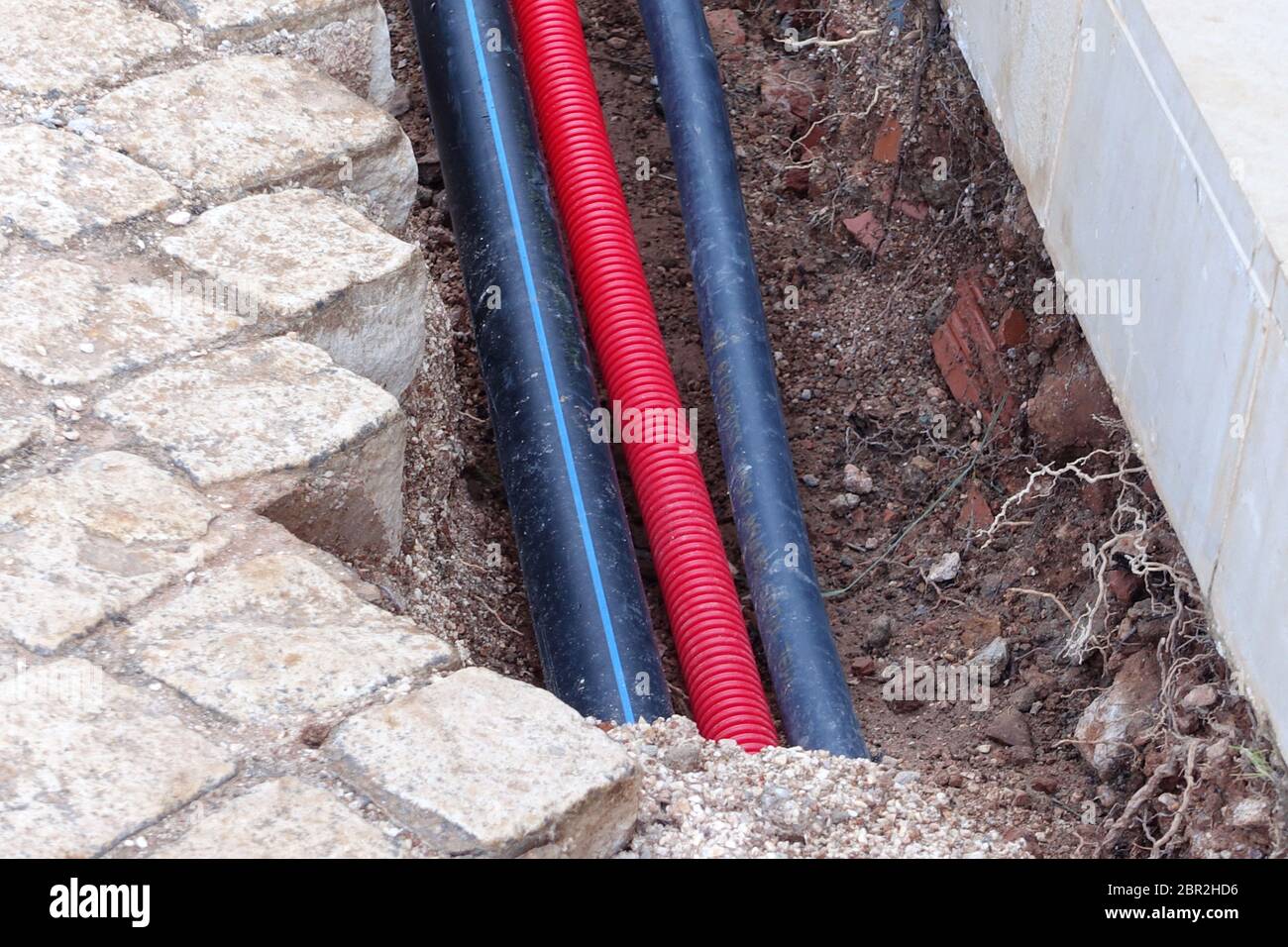 Pipes and cables being laid under driveway Stock Photo Alamy