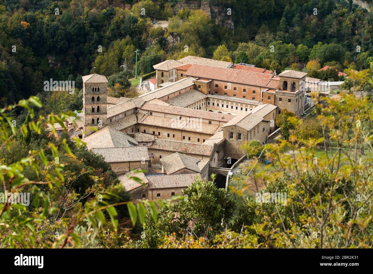 View of Saint Scholastica medieval monastery surrounded, by trees in Subiaco. Founded by Benedict of Nursia Stock Photo