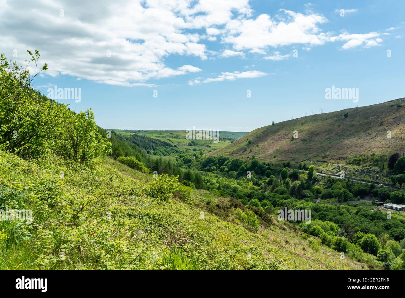 Looking down a valley towards hills and fields in the distance Stock Photo