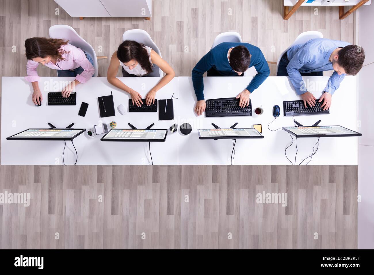 Young Businesspeople Analyzing Gantt Chart On Computer At Workplace Stock Photo