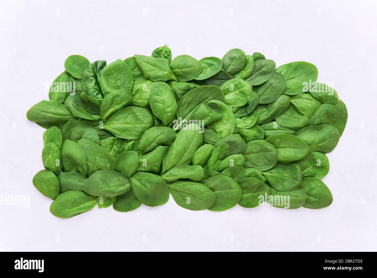 Fresh green spinach leaves on light background. Organic food. Top view, copy space for text Stock Photo