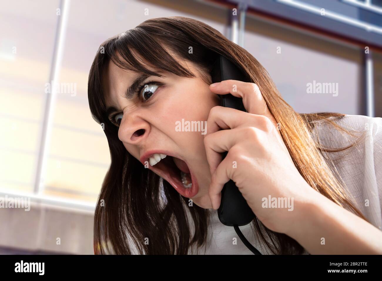 Close-up Of Frustrated Businesswoman Yelling On Phone Stock Photo