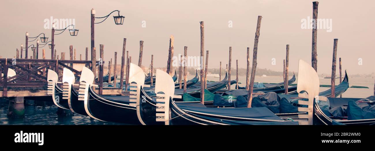 Panoramic view of gondolas and wooden pier in winter in Venice, Italy Stock Photo