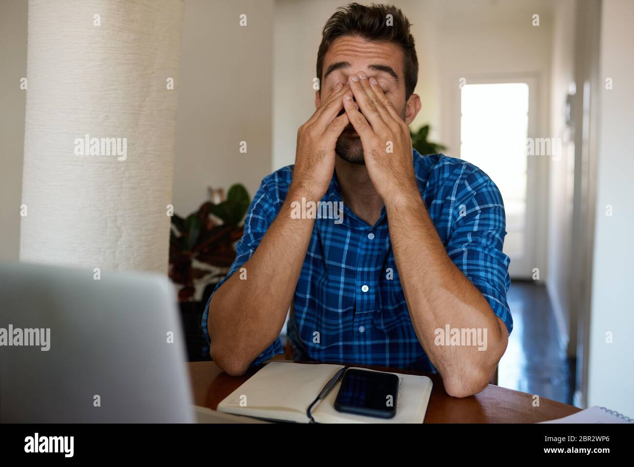 Man looking tired while working remotely from home Stock Photo
