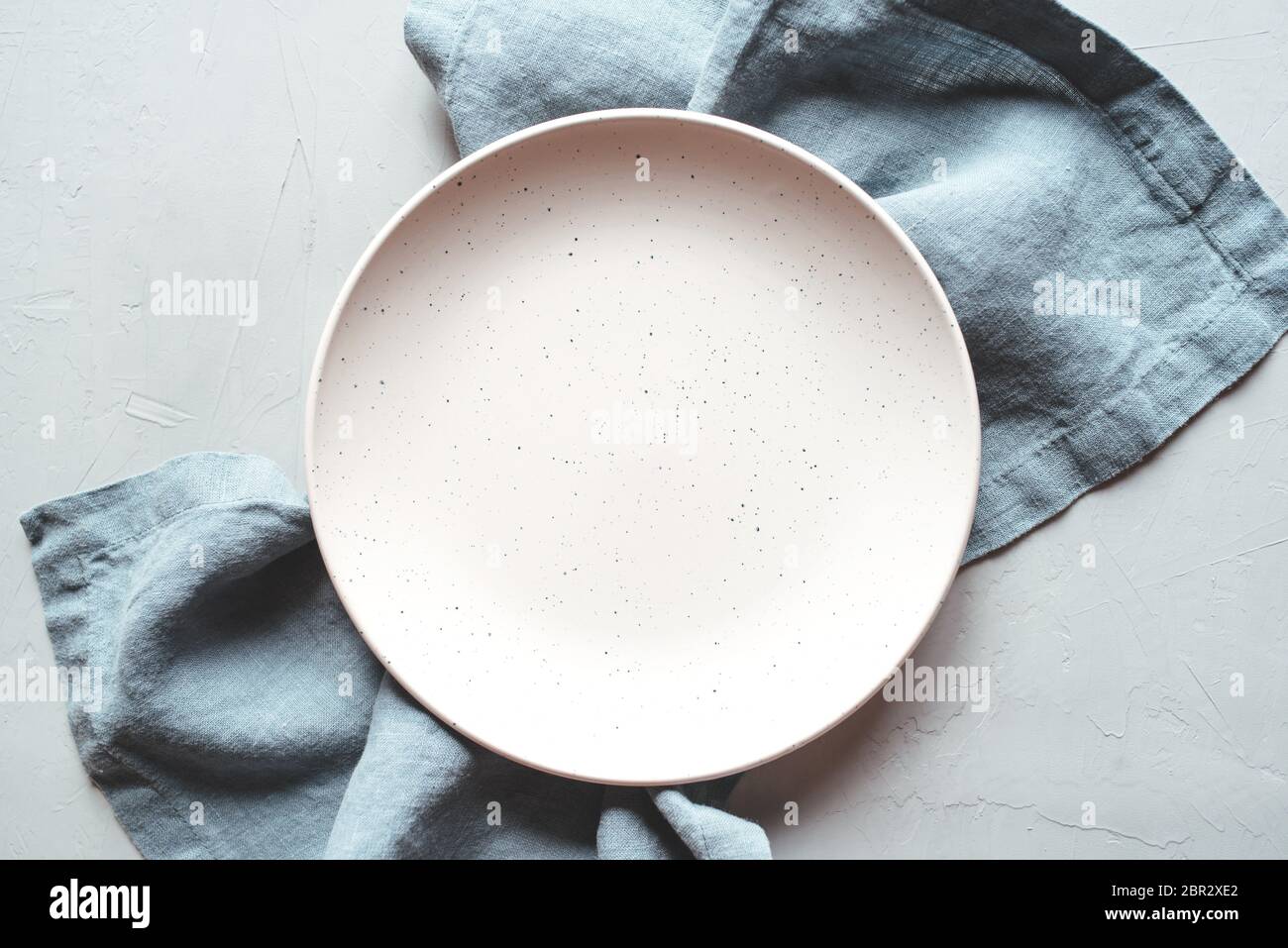 An empty plate and napkin on the gray background. Stock Photo