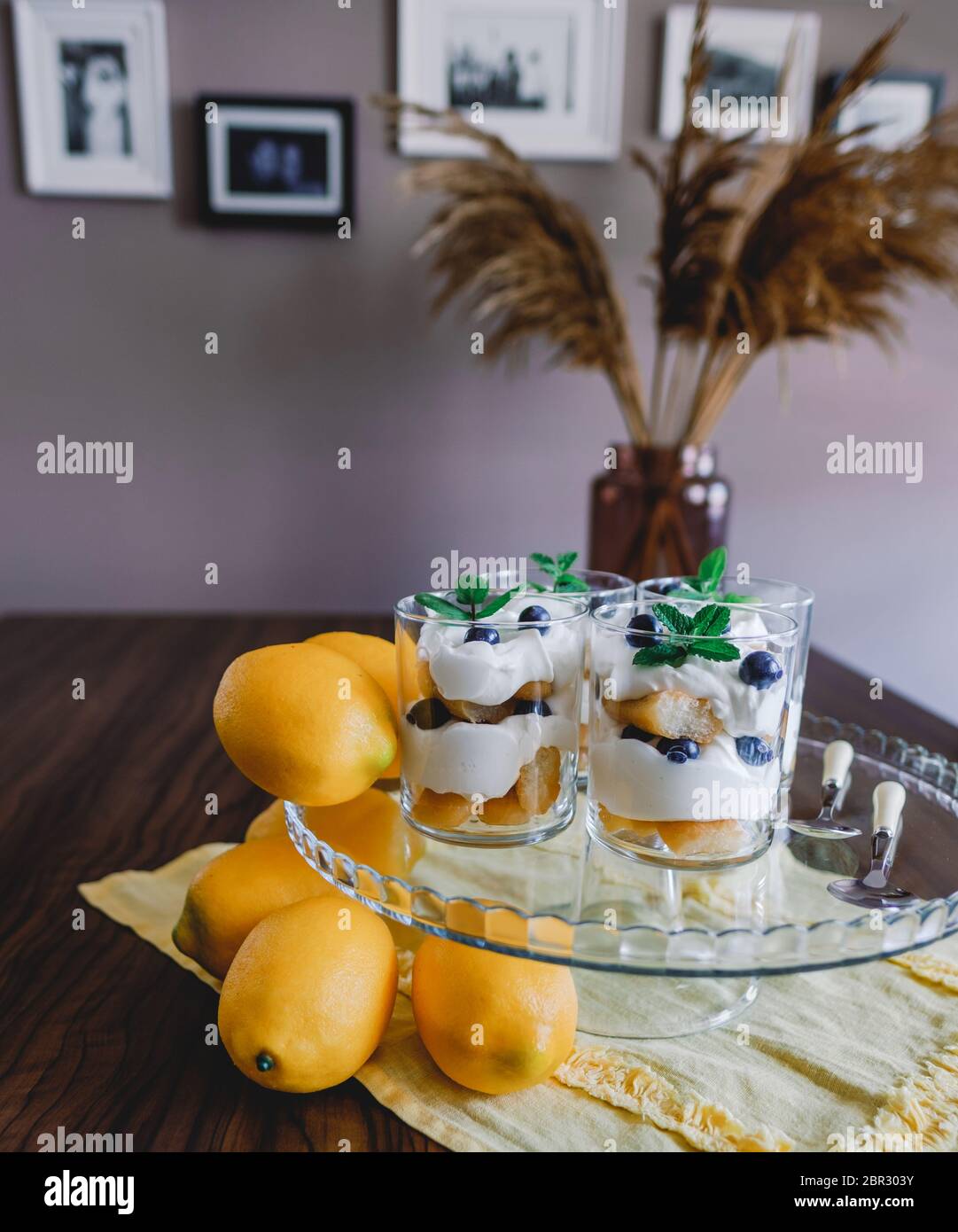 Homemade tiramisu with lemons served on table. Top view of delicious dessert in glass cups. Stock Photo