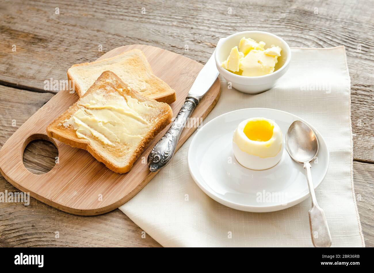 Boiled egg with crispy toasts on the wooden table Stock Photo
