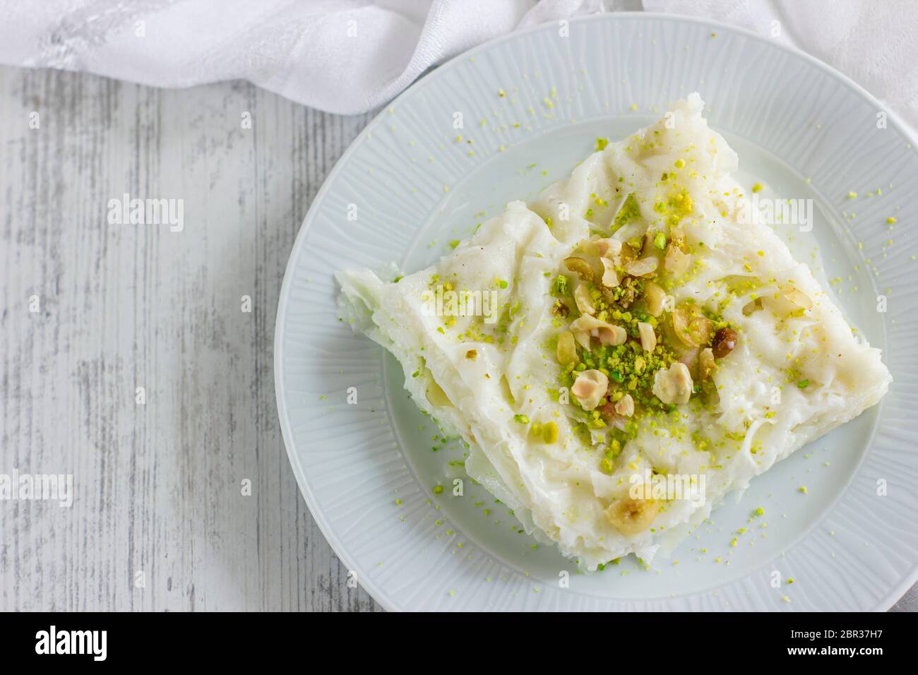 Traditional turkish meal - Gullac. Milk dessert sprinkled with ground nuts and pistachios. Ramadan dish Stock Photo
