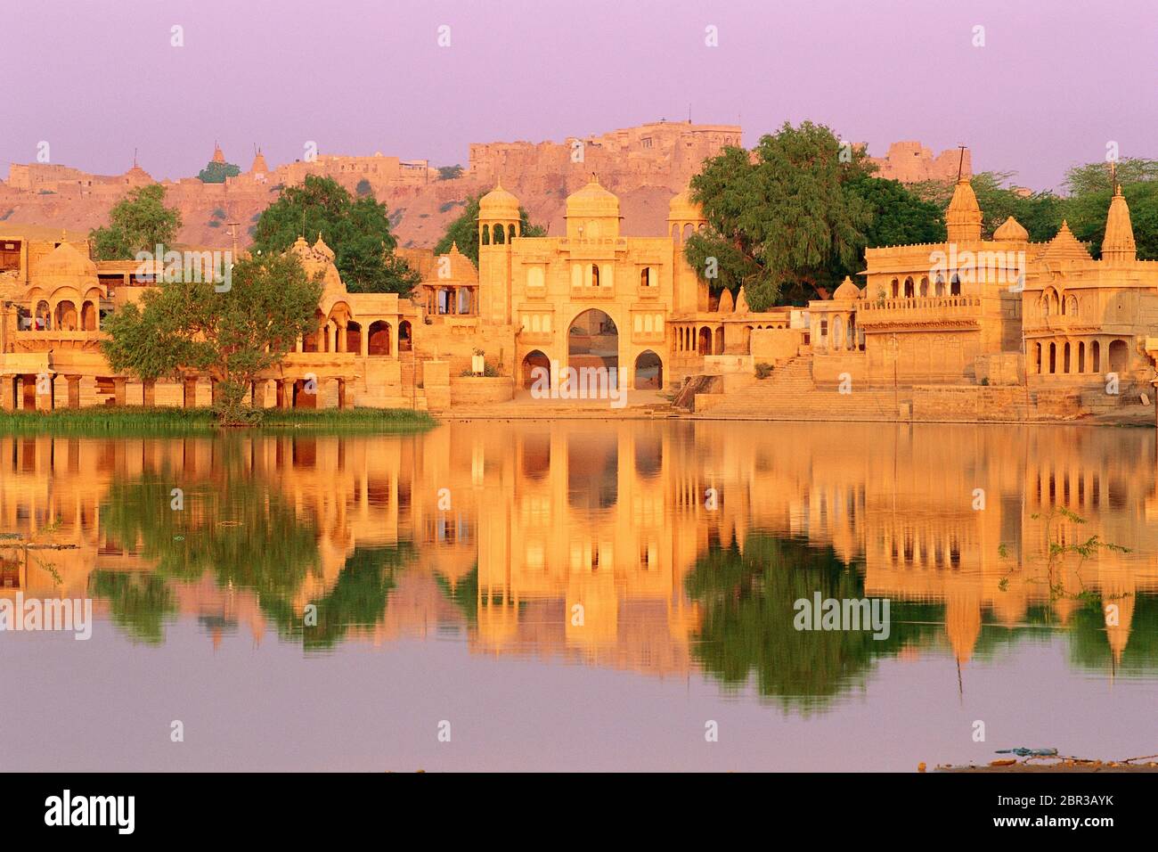 Historic Gateway on the shores of Gadi Sagar Lake with Jaisalmer Fort in the background, Jaisalmer, Rajasthan, India Stock Photo