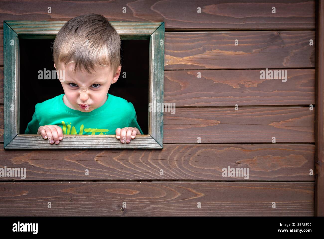 Portrait of a cute cheeky little Caucasian boy looking through the ...