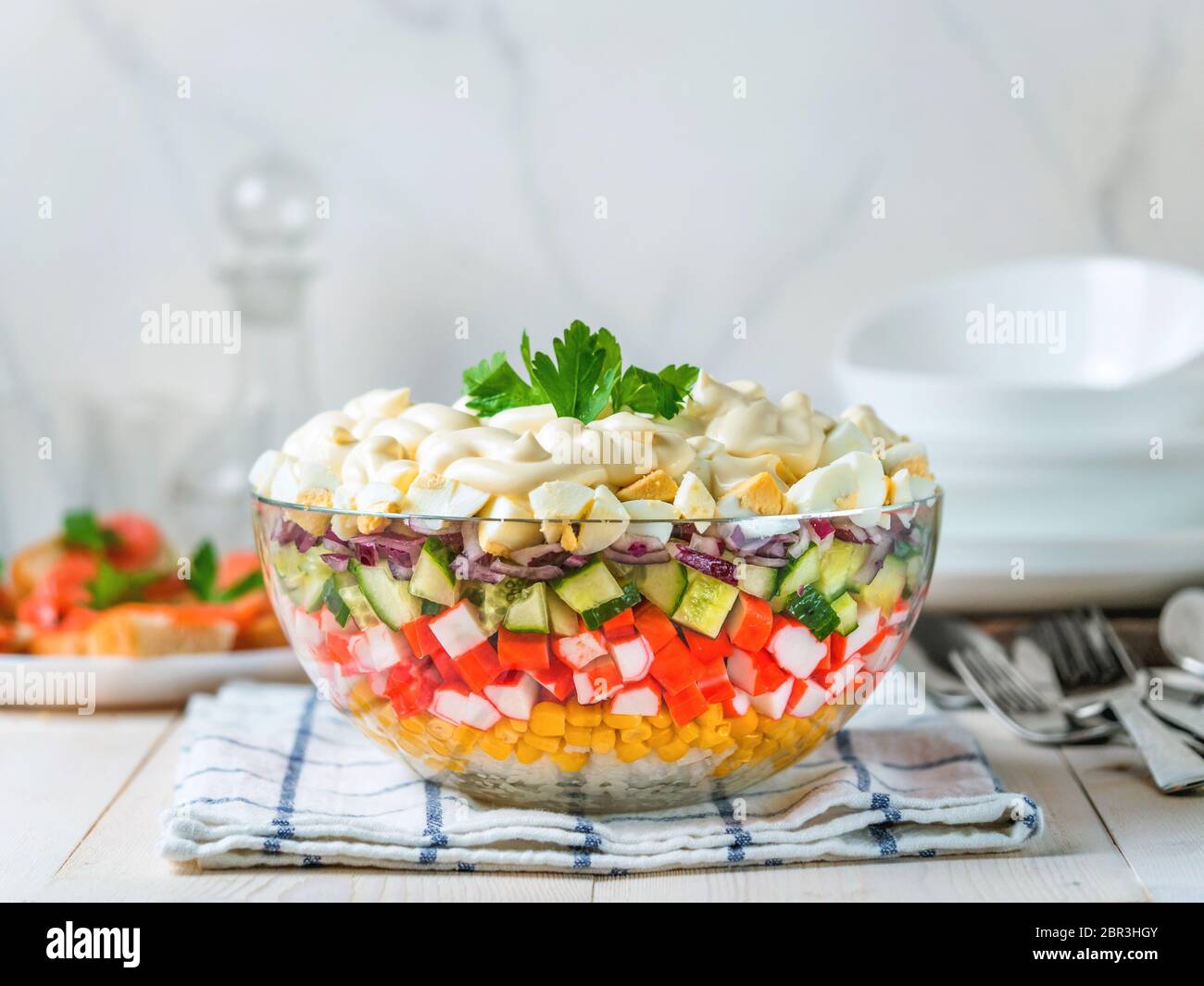 Large glass bowl with crab salad, corn, cucumber and rice at table. Layered  crab sticks and corn salad. Traditiolnal mayonnaise salad for russian holi  Stock Photo - Alamy
