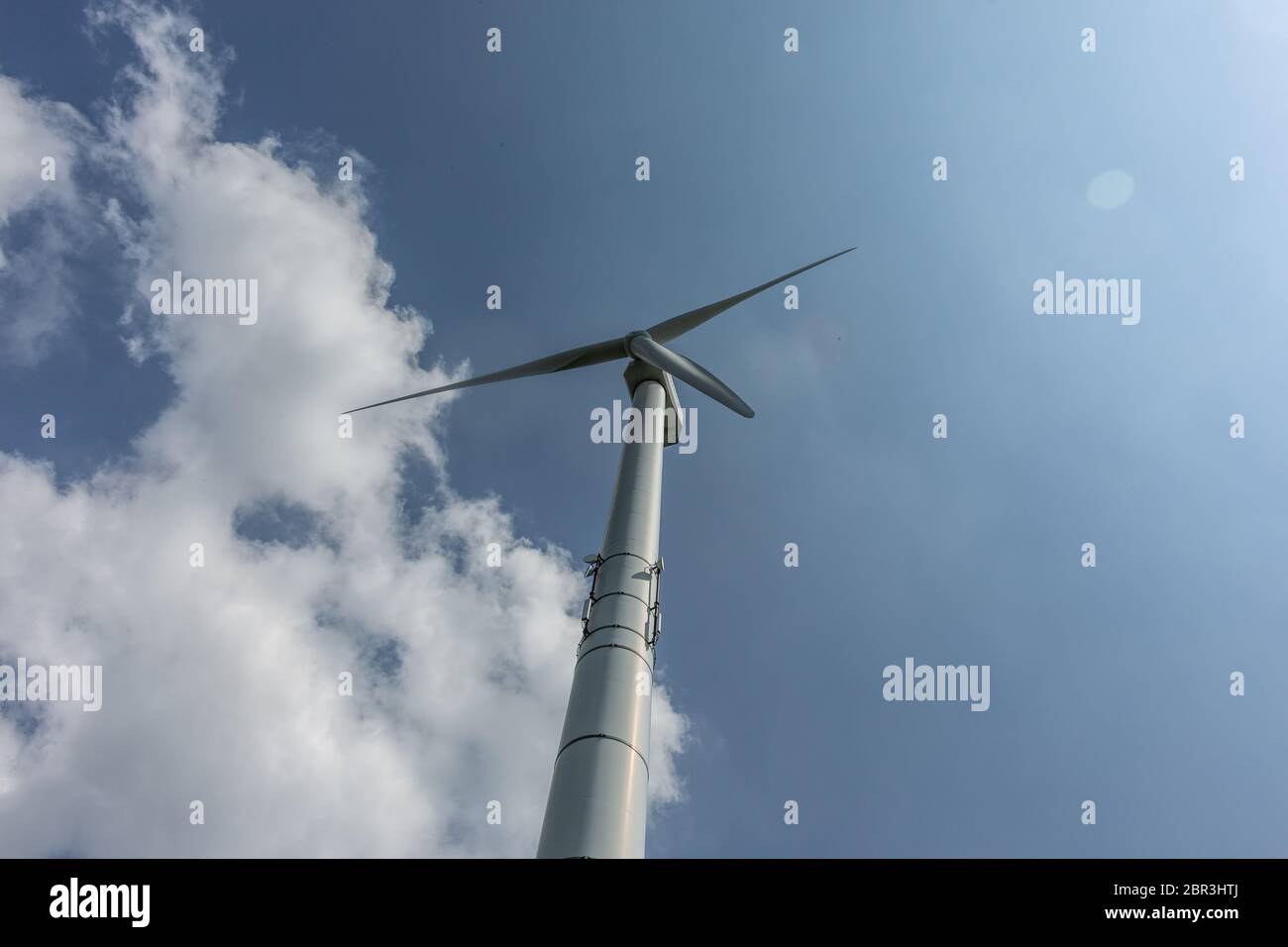 Wind turbine against a bright blue sky with clouds Stock Photo - Alamy