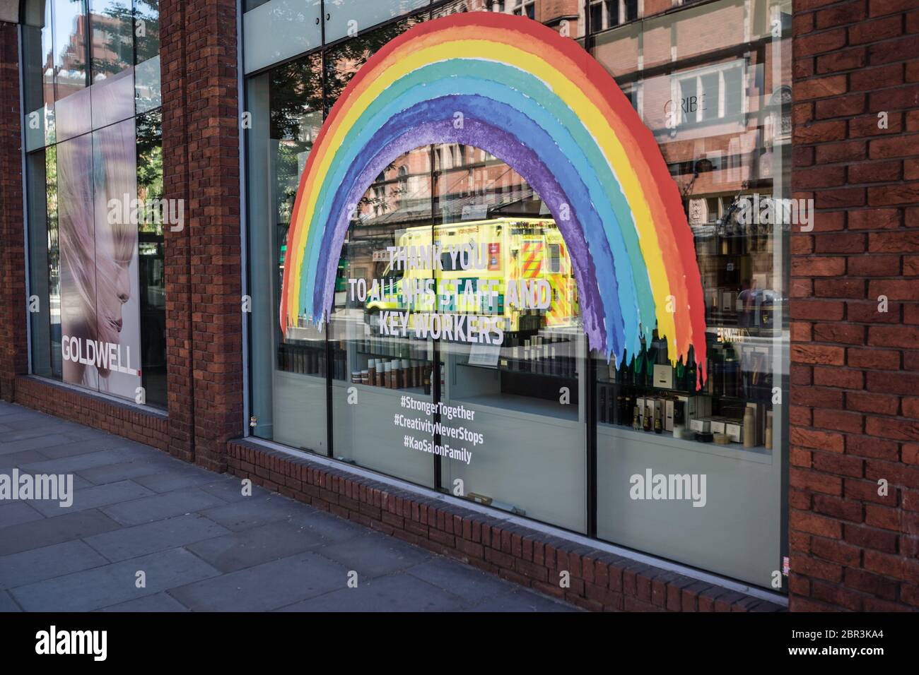 An ambulance passes by a rainbow in the window of a shop thanking the Key Workers in a deserted London during the coronavirus pandemic in UK. Stock Photo
