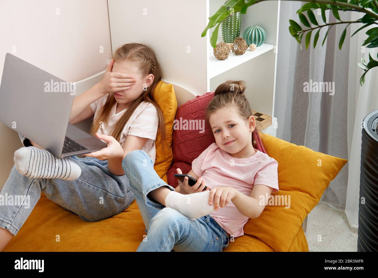Two little sisters using laptop lying on bed at home Stock Photo - Alamy