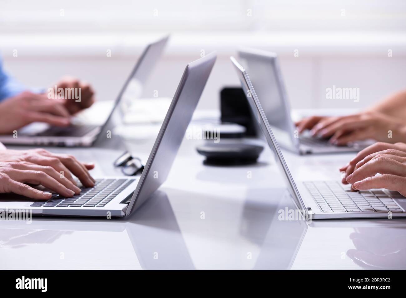 Close-up Of A Businessman Hands On Laptops Keypads On Desk In Office Stock Photo