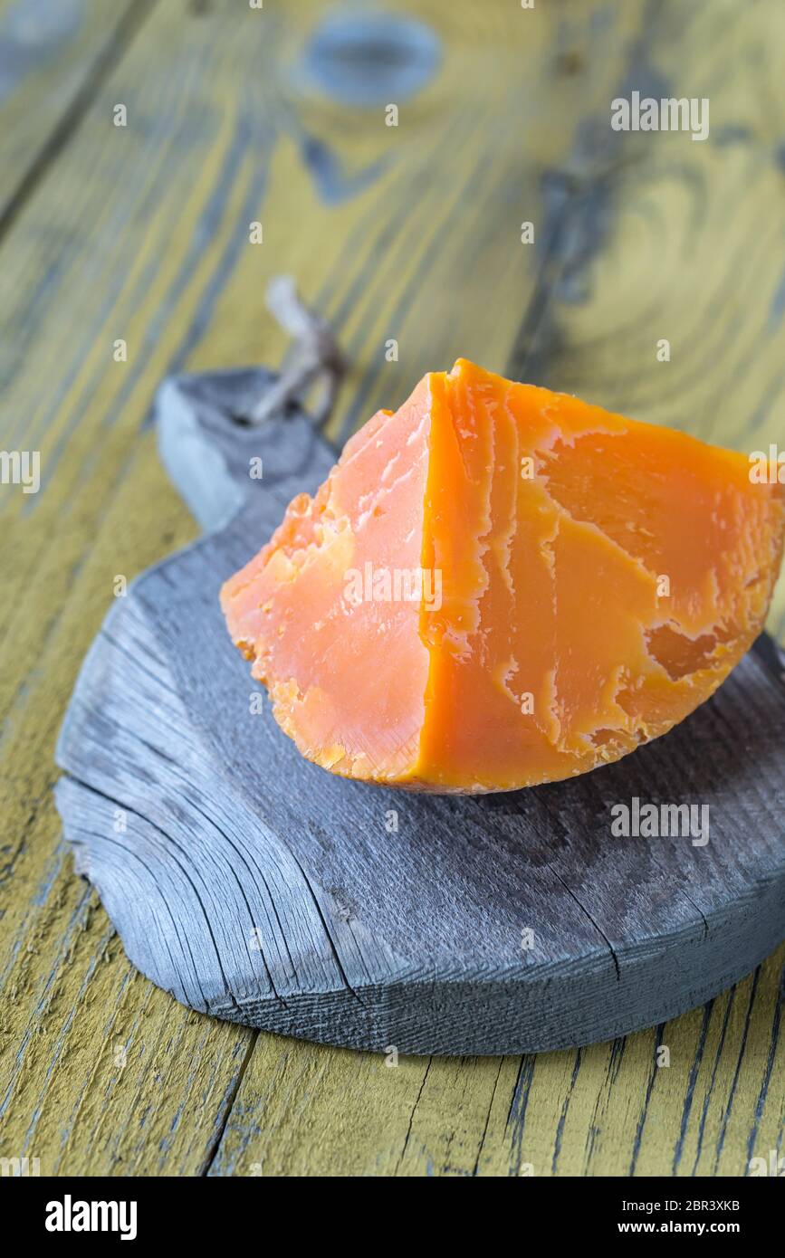 Wedge of Mimolette cheese on the wooden board Stock Photo