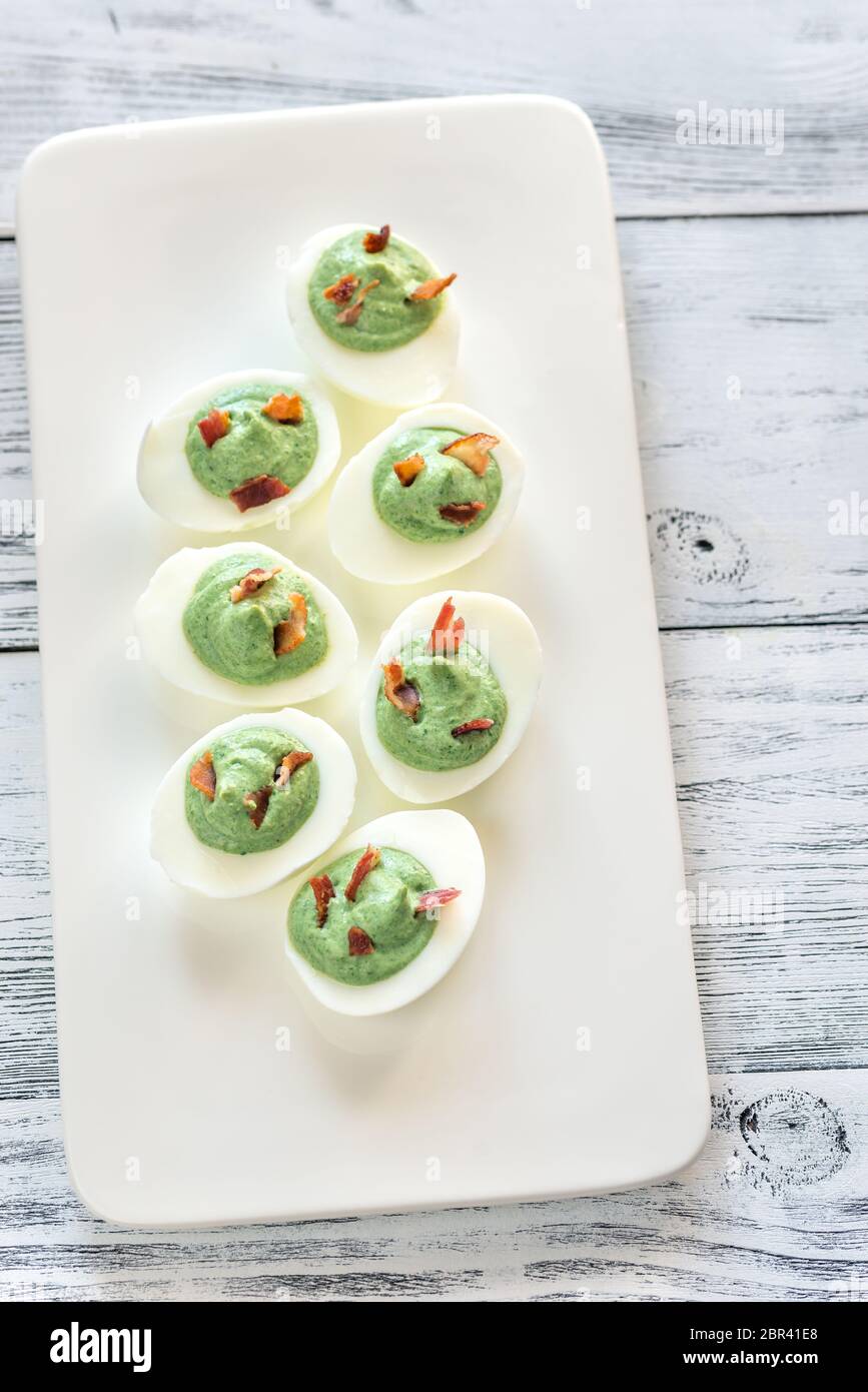 Spinach and bacon deviled eggs Stock Photo