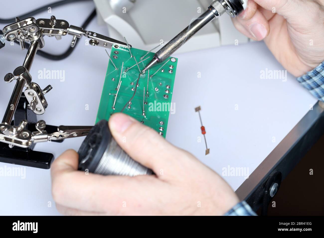 electric technician is soldering some digital devices Stock Photo